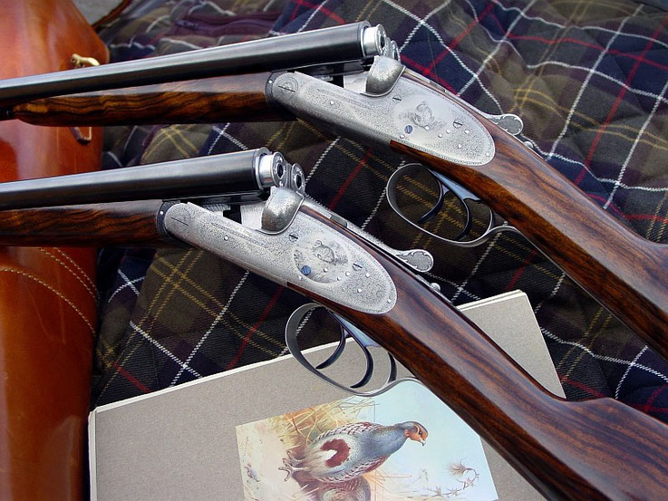 A pair of fine 20 gauge side by side shotguns, finely engraved with scenes after Archibald Thorburne and English Fine Scroll