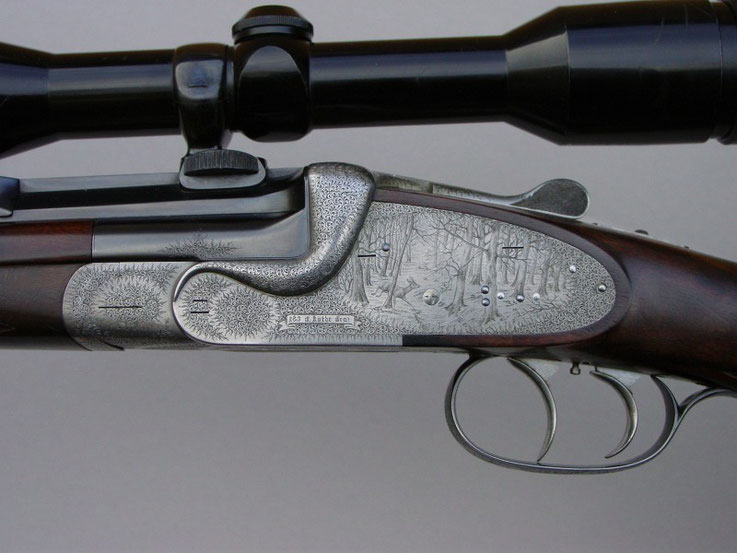 A break action single barrel rifle engraved with English Fine Scroll and game scenes with roe deer