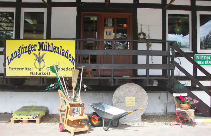 Eingangsbereich des Langlinger Mühlenladen mit Gartenwerkzeug davor