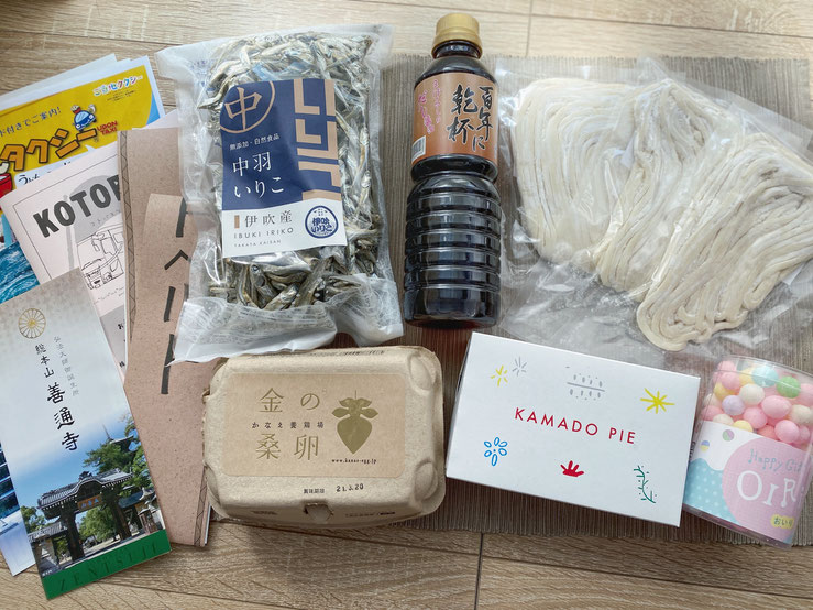 ▲自宅に届いた旅のしおり、シートベルト、特産品
