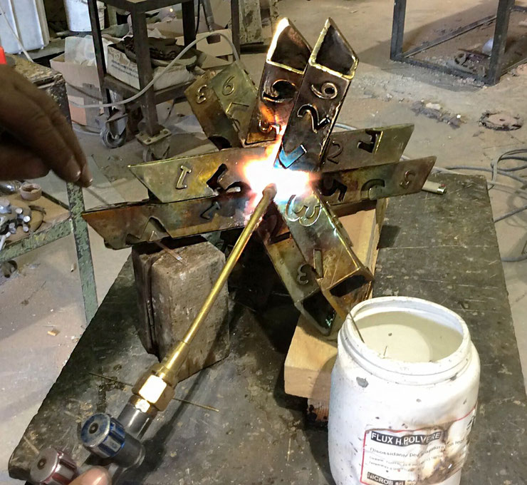 Close-up of Paolo Grassi’s Rigoberta bronze sculpture during welding process in the studio, showing structural complexity and numbered design
