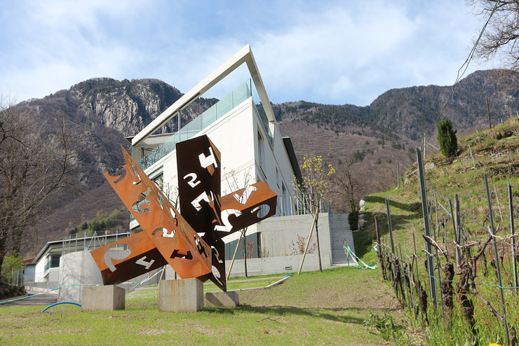 Wide view of sculpture installed in front of house