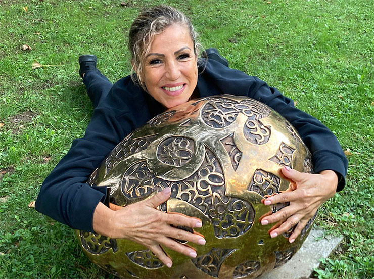 big egg sculpture embraced by woman visitor paolo grassi