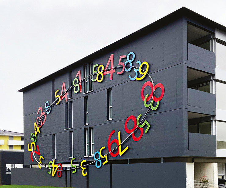 Colored numbers installation by Paolo Grassi on a building facade in Cadenazzo.