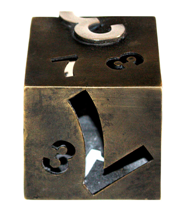 Dark patinated bronze edition of Paolo Grassi’s Dado sculpture, frontal view with numbers 3, 2, 7