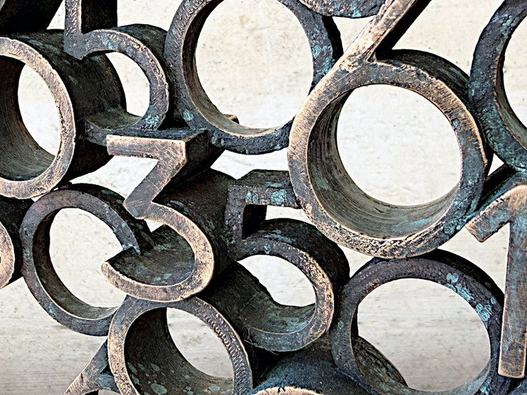 Paolo Grassi, Birba bronze sculpture from the project From ‘0’ to Infinity, close-up detail showing overlapping numbers, textured bronze surface and dark patina.