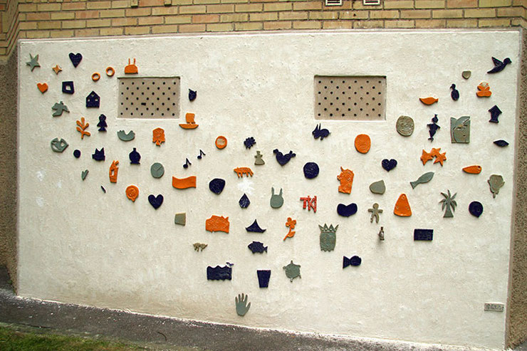 Portion de mur réalisée en 2013 (première partie). Les pièces émaillées ont été collées par le public, la maçonnerie de finition n'a pas encore été faites.