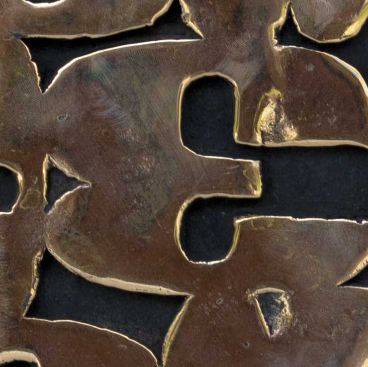 Detail of Paolo Grassi’s Box sculpture, showing engraved numbers and polished bronze texture