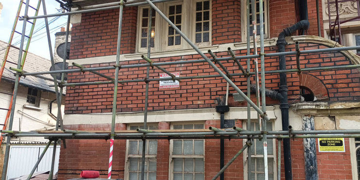 Picture of a house with scaffolding and dark coloured brick pointing 