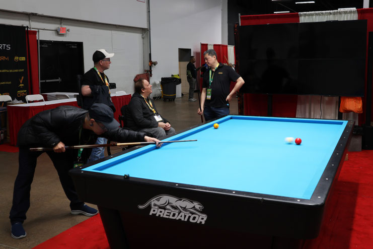 PREDATOR CRMブースのテーブルで球を撞く酔爺