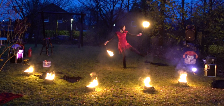 Beispiel Aufbau meiner Feuershow, vorne 5 Feuerschalen im Halbkreis, hinten zwei Lautsprecher links und rechts, in der Mitte Tanzt die Künstlerin.