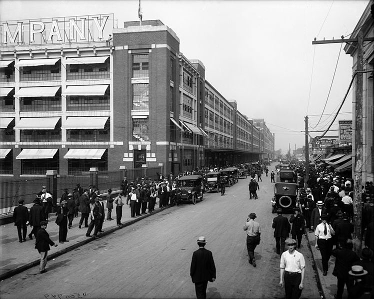 Ford Motor Company Auto-Montagefabrik in Detroit, Michigan (1910er Jahre) / Bild: https://commons.wikimedia.org/wiki/File:Change_of_work_shift_at_Ford_Motor_Company.jpg)