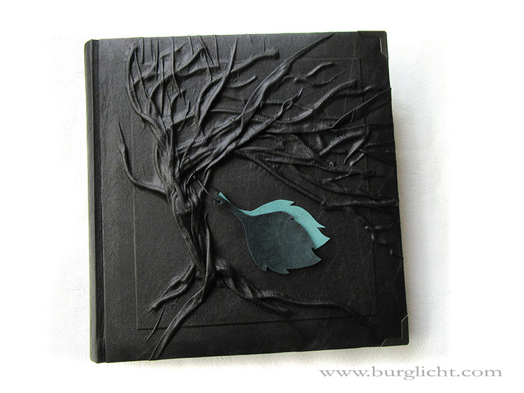 Fotoalbum Hardcover Hochrelief Baum, Bucheinbandmaterial Stoff schwarz, Blatt-Applikationen aus Echtleder hell- und dunkelgrün, Buchecken mattschwarz, 30cm x 30cm, 100 Seiten schwarz mit Pergamin