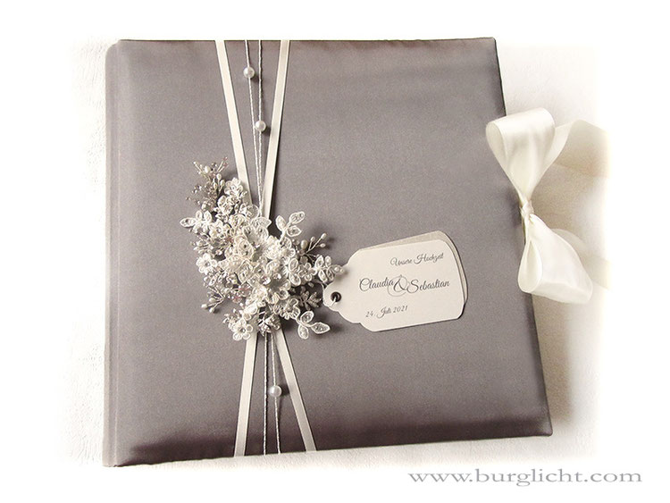 Hochzeitsfotoalbum, gepolsterter Hardcover-Bucheinband, Stoff Satin taupe, Bucheinbandgestaltung Schleifenverschluss hellcreme, Label bedruckt, Haarschmuck, Perlen und Bänder.