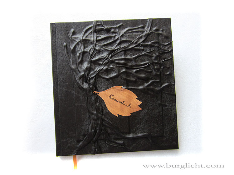 Trauerbuch, Hardcover-Bucheinband, Hochrelief Baum, Bucheinbandmaterial Stoff schwarz, Blatt-Anhänger Holzoptik bedruckt, Buchblock Fadenheftung, 128 Seiten weiß, Hochformat 21cm x 24cm.