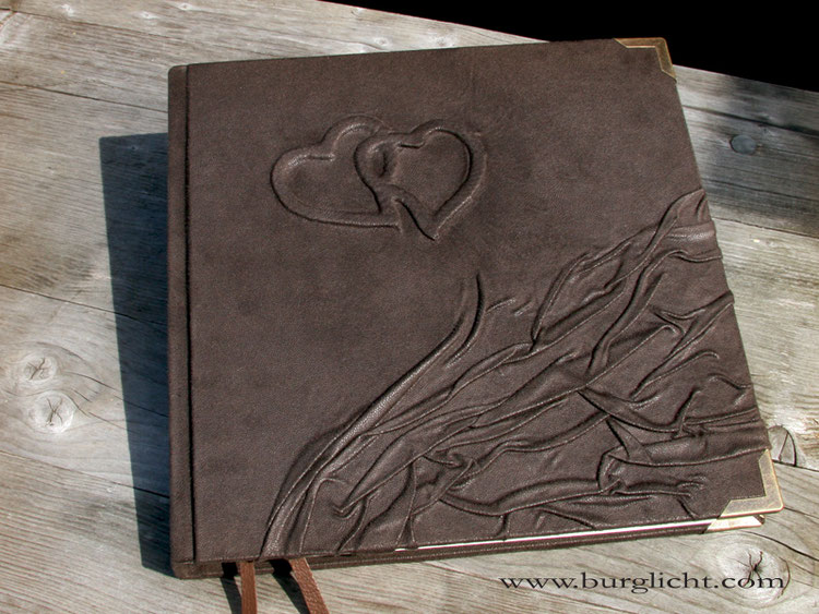 Quadratisches Buch, 21cmx21cm, Flachrelief 2 Herzen, Bezug Velour-Stoff braun, mit schützenden antikmessingfarbenen Buchecken aus Metall; Buchblock 120 Seiten in traditioneller Fadenheftung, Künstlerpapier ivory.