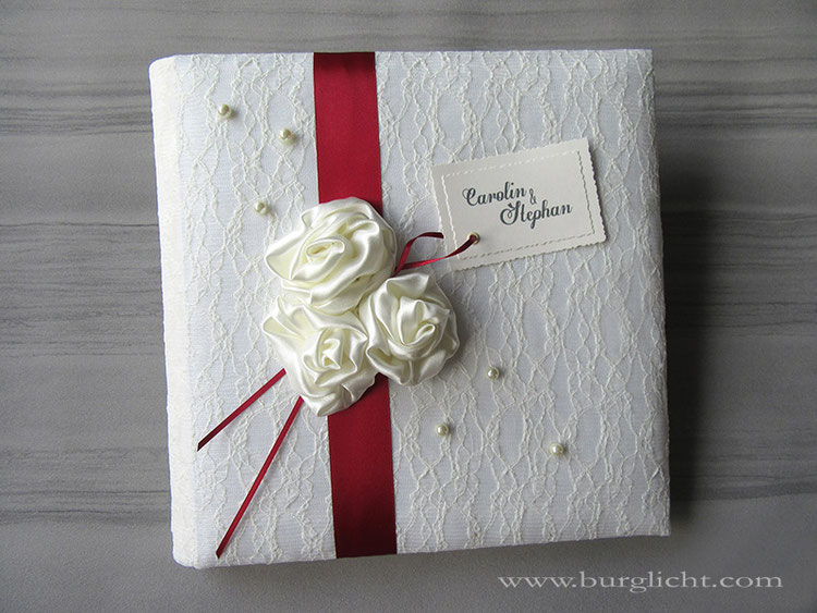 Hochzeitsfotoalbum, Hardcover gepolstert, Bucheinbandmaterial Stoff Spitze/Lingerie naturweiß, handgenähte Satinrosen champagnerfarben, Zierperlen, bedrucktes Label, 30cmx30cm, 50 Blatt Off-White.