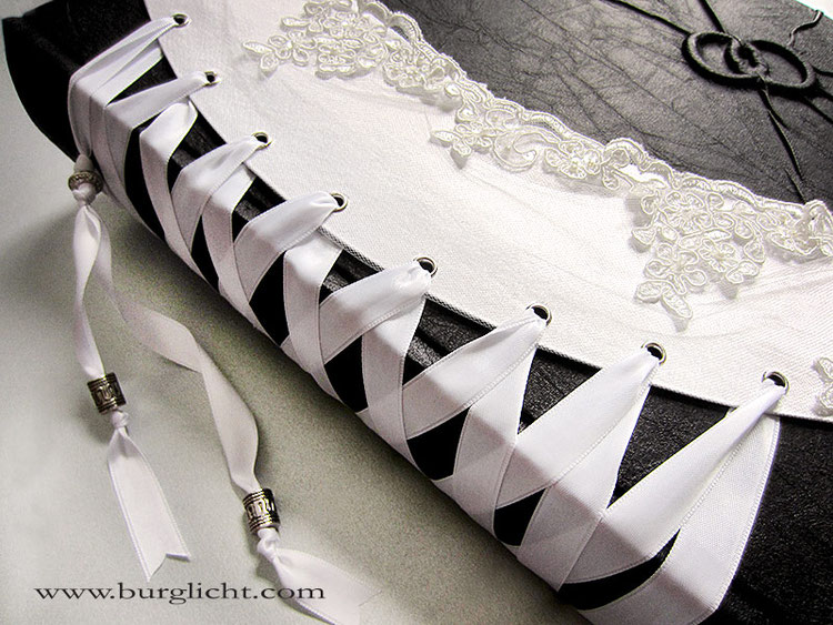 Hochzeitsalbum Corsage, 29cmx32cm Hochformat, 100 Seiten schwarz, Bucheinbandmaterial Stoff schwarz, Corsage Stoff weiß darüber Tüll mit Spitzenborte, Schnürung Satinband DoubleFace, Relief Ringe, Metallteile vernickelt.