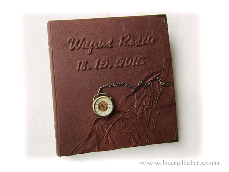 Fotoalbum Zeitreise, 30cm x 33cm Hochformat, 50 Blatt weiß, Hardcover-Bucheinband, Bezug Stoff rotbraun, Relief Text, mechanische Taschenuhr, Metall-Buchecken