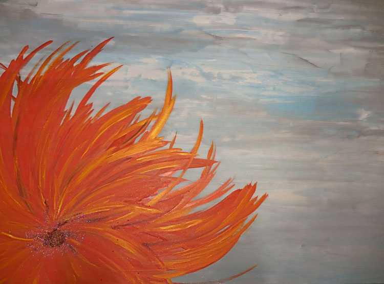 orangene Dahlie im Wind mit Perlen als Blüteninnerem und einem wolkigen Himmel als Hintergund