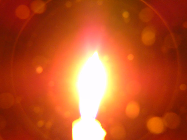 Eine kleine weiße Kerze erstrahlt bei geöffnetem Herzen/ Quelle: www.lichtwesenfotografie.com