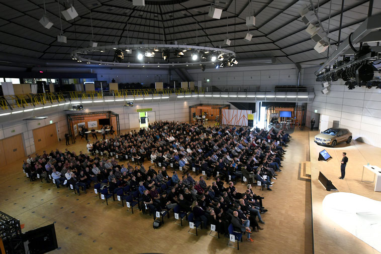 welcome-net Stuttgart, Eventagentur, Gäste im Plenum, Redner auf Bühne im Mercedes Event Center, Führungskräfte-Veranstaltung, Jahresabschluss