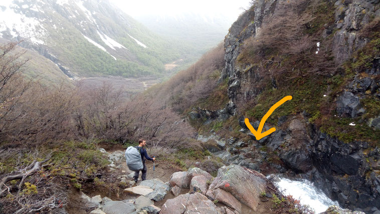 Jérôme est devant une cascade sur le flan de la montagne et cherche le chemin pour la traverser. On voit un peu la montagne enneigée au fond!