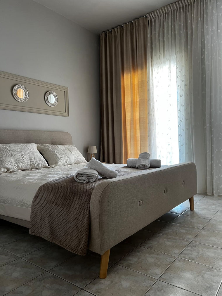 Schlafzimmer mit Doppelbett und Zugang zum Balkon