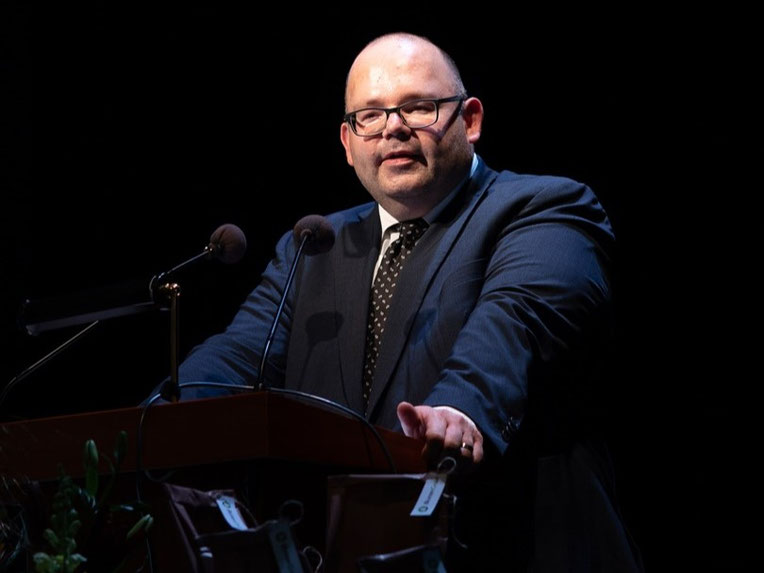 Armin Hartmann spricht als Festredner am Rednerpult bei der Maturafeier 2026 der Kantonsschule Reussbühl.