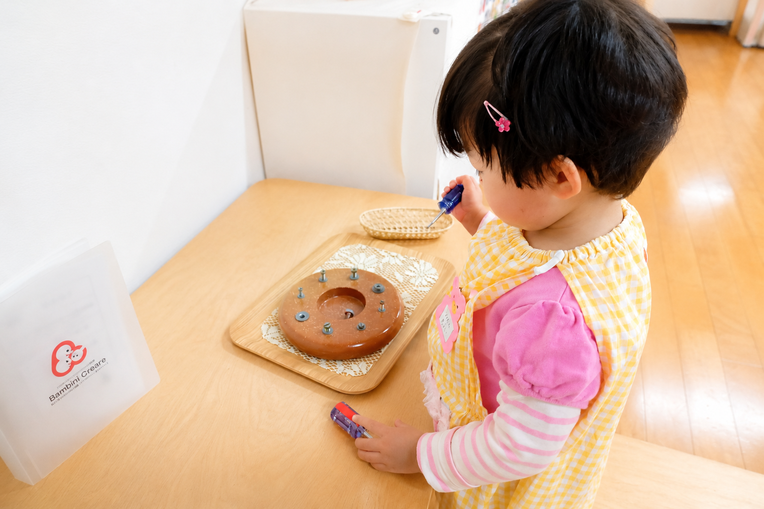 京都市の幼児教室バンビーニクレアーレで、モンテッソーリ活動に集中して取り組む2歳児