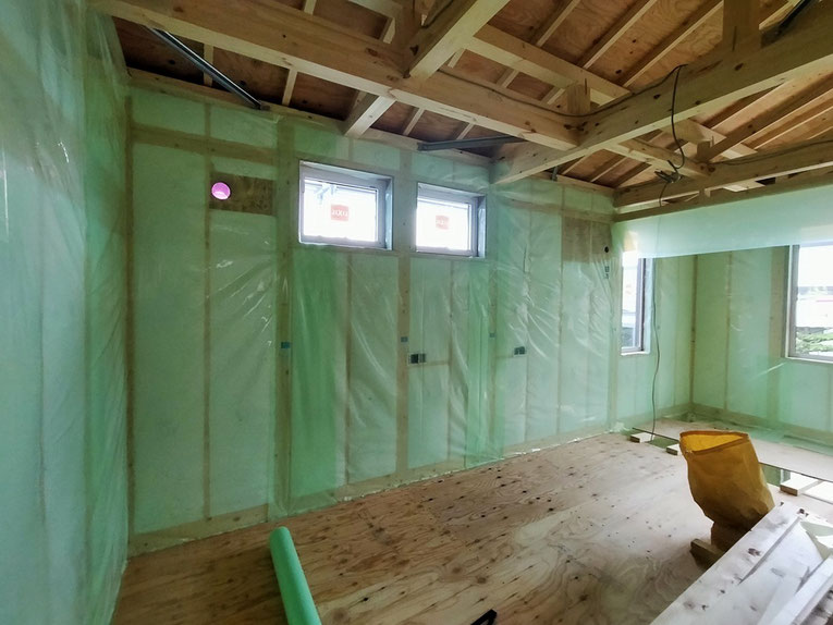 複数の窓の周囲に気密シートがしっかり貼られた木造住宅の2階 施工現場
