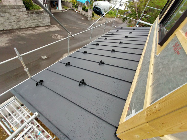 金属屋根材が整然と並ぶ屋根面。留め具が見える。