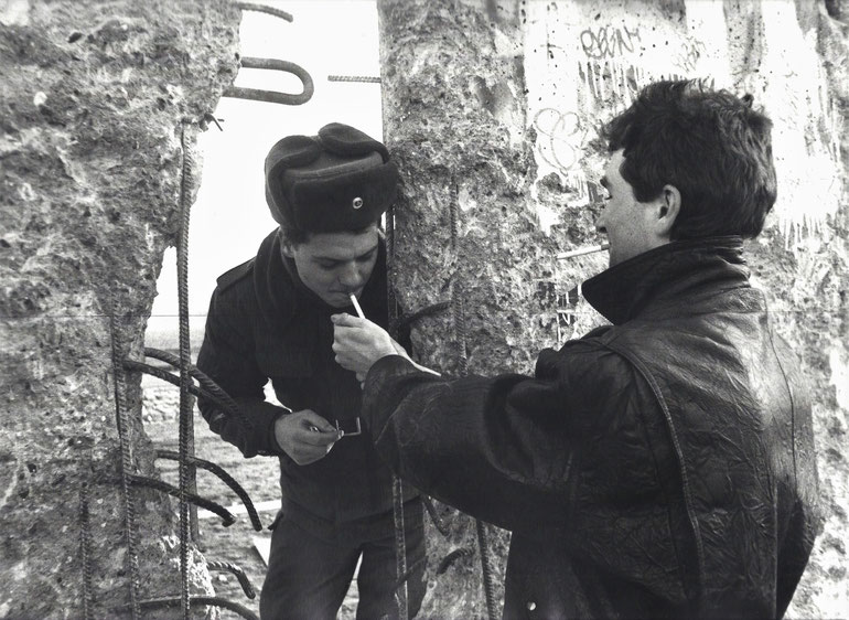 Rauchen verbindet. Eine alte Kulturtechnik an der Berliner Mauer im Januar 1990. Foto: Maria Notbohm