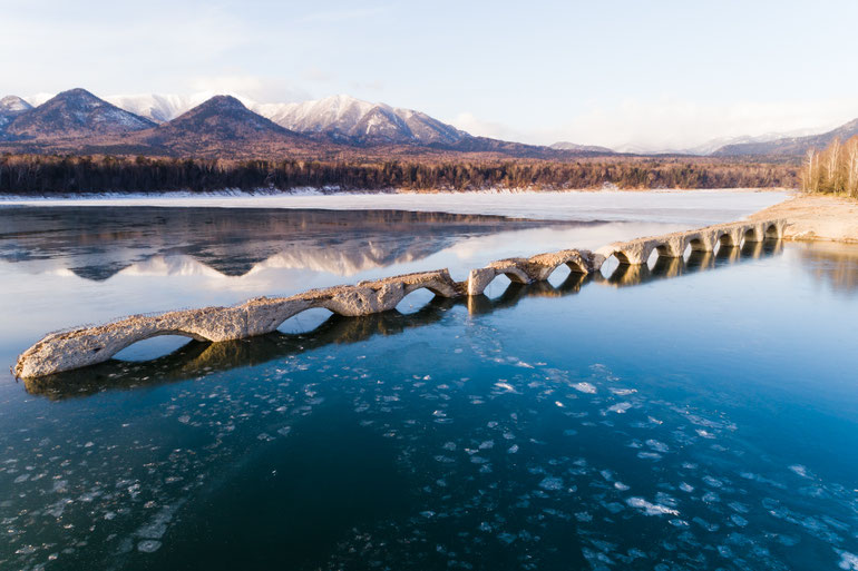 2020 — Reflected in early winter water, partially submerged beneath forming ice.