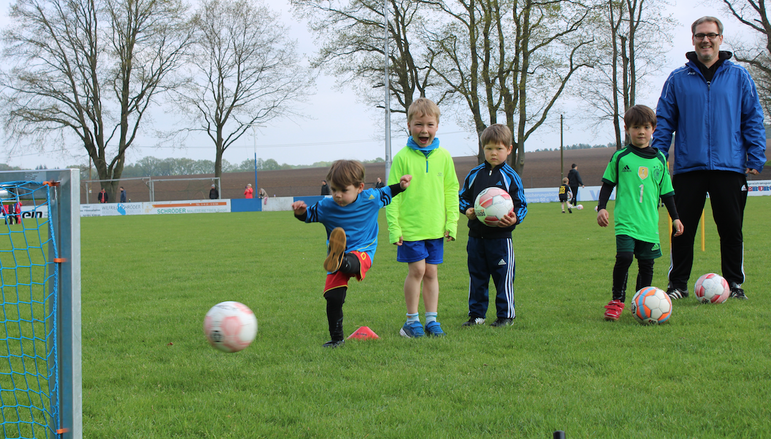 Foto: Fußballspielende Kinder auf dem Sportplatz