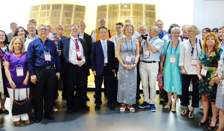 The museum’s head curator, Dr Jeong-Ha Hwang, with the International Association of Printing Museum delegates standing before the Jikji display.