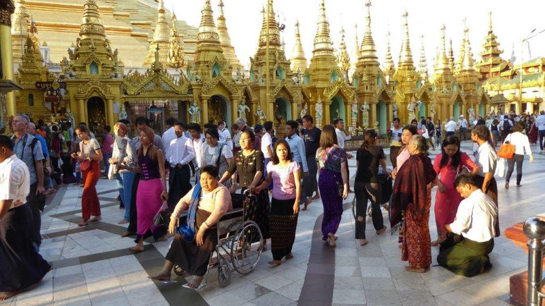 Bild: Foto zeigt die Shwedagon Pagode, um die viele Besucher herumfingern