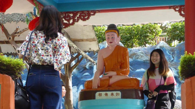 Bild: Lachende Chinesinnen an einer Buddha Figur zur Fotografie 