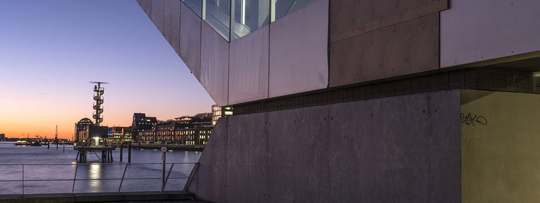 Norderelbe und Dockland bei Nacht in Hamburg als Farbphoto im Panorama-Format. 