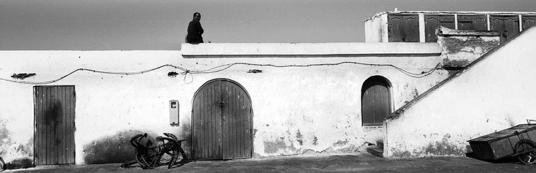 Fischer im Hafen von Essaouira in Marokko in schwarz-weiß als Panorama-Photographie