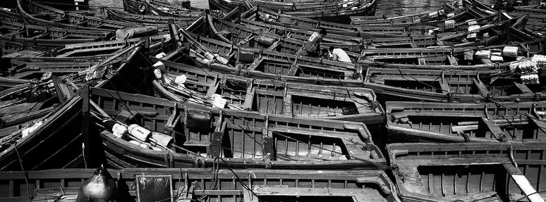 Fischerbote im Hafen von Essaouira in Marokko in schwarz-weiß als Panorama-Photographie