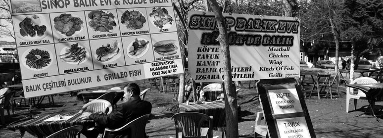 Mann auf dem Fischmarkt  in Karaköy in Istanbul, Türkei als Schwarzweißphoto im Panorama-Format