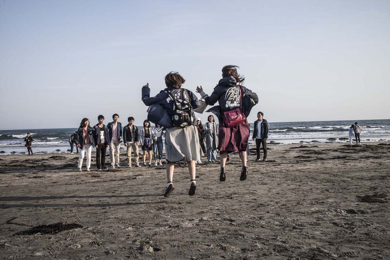 Schüler fotografieren sich gegenseitig auf dem Yuigahama Beach in Kamakura, Japan als Farbphoto