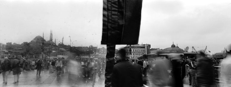 An der der Galata Brücke im Regen in Istanbul, Türkei als Schwarzweißphoto im Panorama-Format