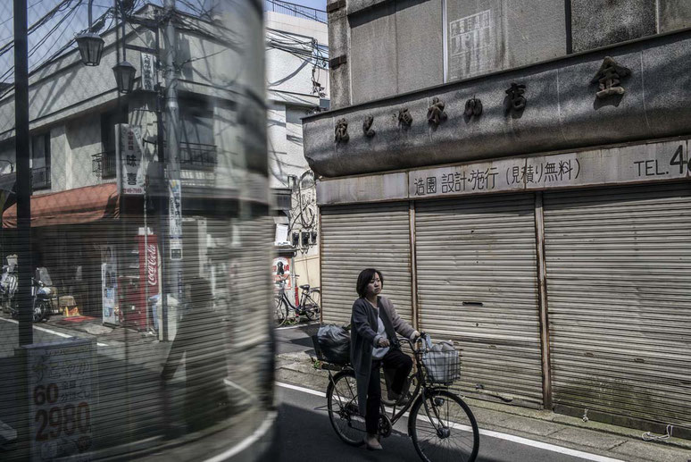 Frau fährt durch die Gassen von Ofuna, Japan als Farbphoto