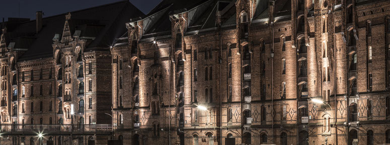 Speicherstadt-Fassaden by night am Zollhafen in Hamburg als Farbphoto im Panorama-Format 