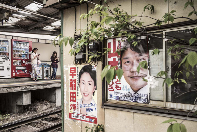 Zwei Frauen schauen in ihr Smartphone im Bahnhof von Enoshima, Japan als Farbphoto