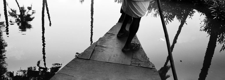 Auf einem kleinen Boot in den Backwaters von Aleppi, Indien, in schwarz-weiß als Panorama-Photographie