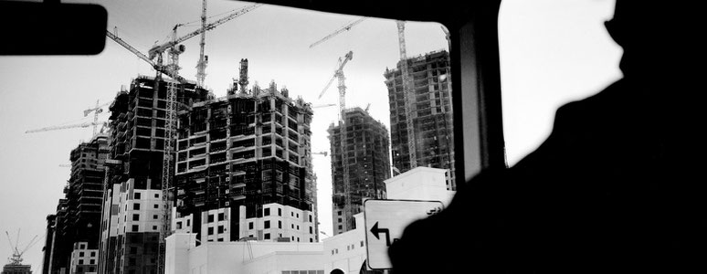 Blick aus dem Minibus auf die Häuserfassaden im Rohbau in der Al Sutouth Road, Dubai, als Panorama-Photographie