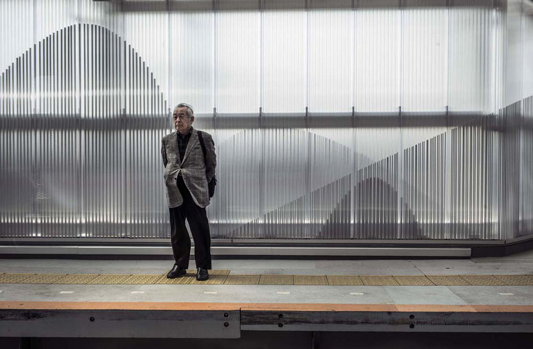 Älterer Mann steht auf dem Bahnsteig im Bahnhof von Ofuna, Japan als Farbphoto